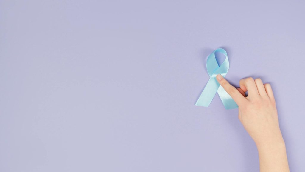 a hand touching a blue ribbon